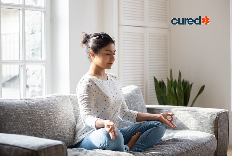 Woman doing Meditating on sofa