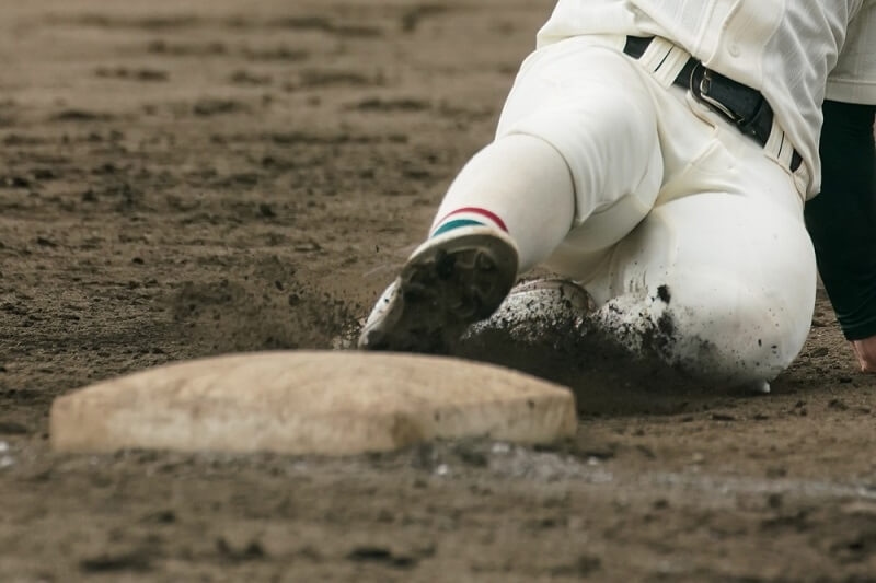 Baseball player sliding into a base while attempting to steal a base during a baseball game