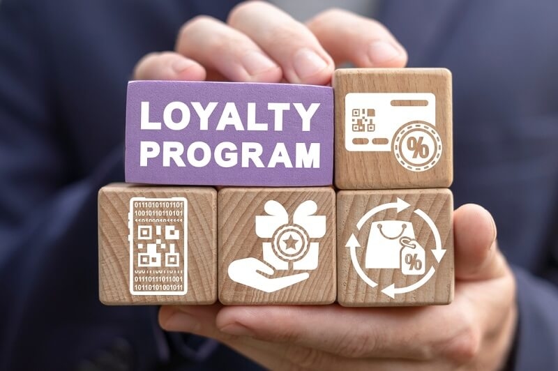 Man holding wooden blocks with loyalty program text