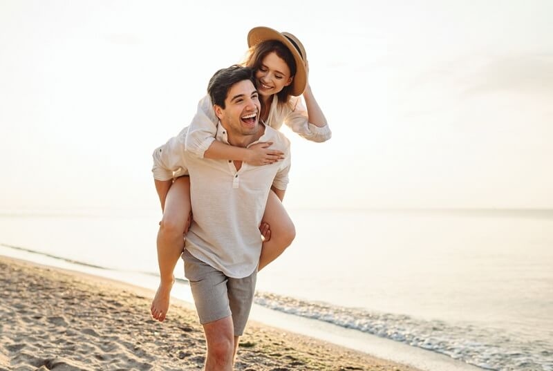 Couple on vacation boyfriend give piggyback ride