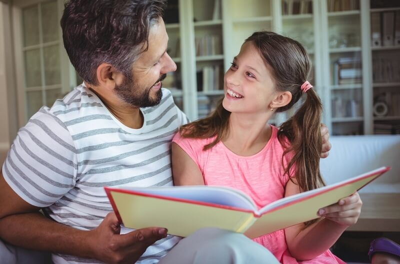 Daughter giving photo album as a father's da gift