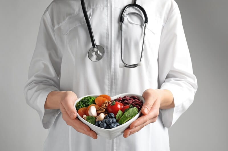 Doctor holding bowl with full of heart-healthy foods