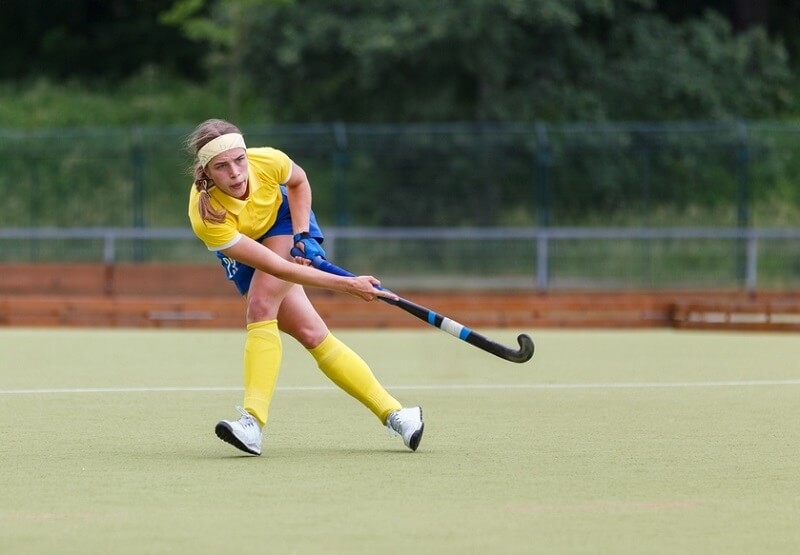 Field hockey player making pass to a teammate in a game