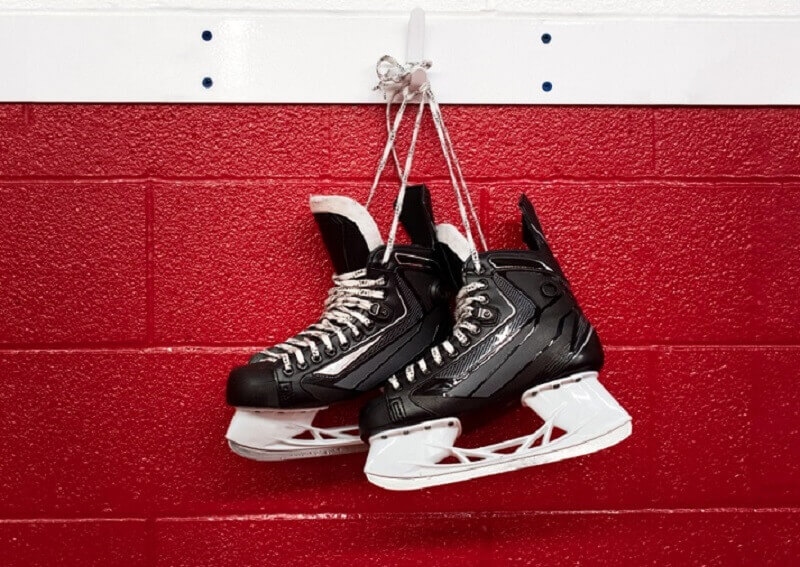 Hockey skates hanging over red wall