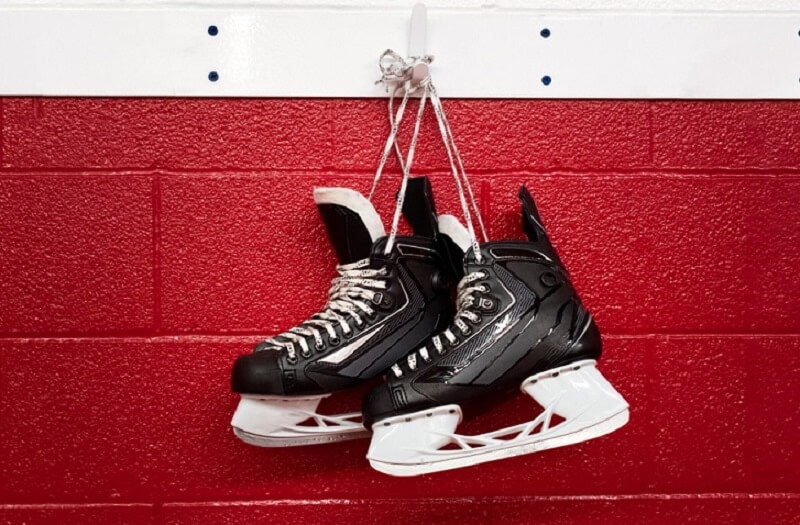 Hockey skates hanging over red wall