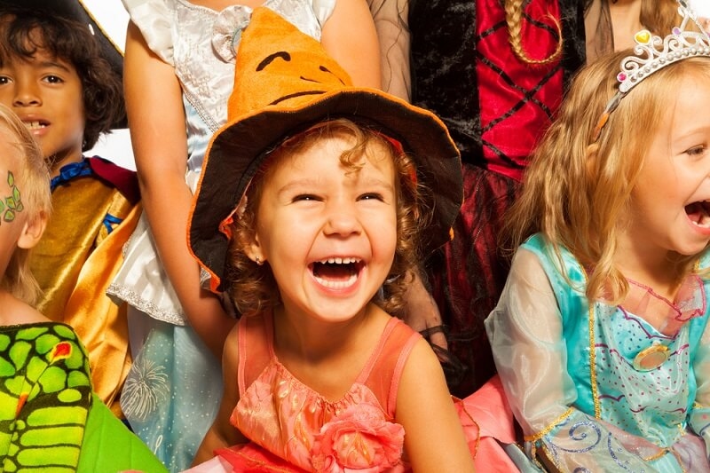 Little girl Laughing in Halloween costume with friends