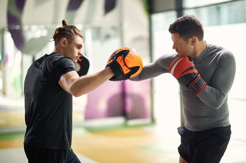 Male sparring partners fighting on boxing training