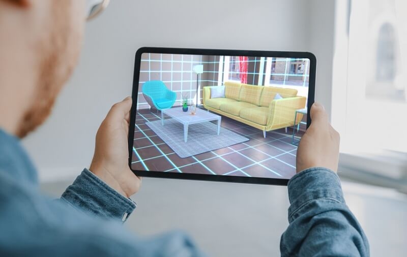 Man Holding Digital Tablet planning furniture positions virtually