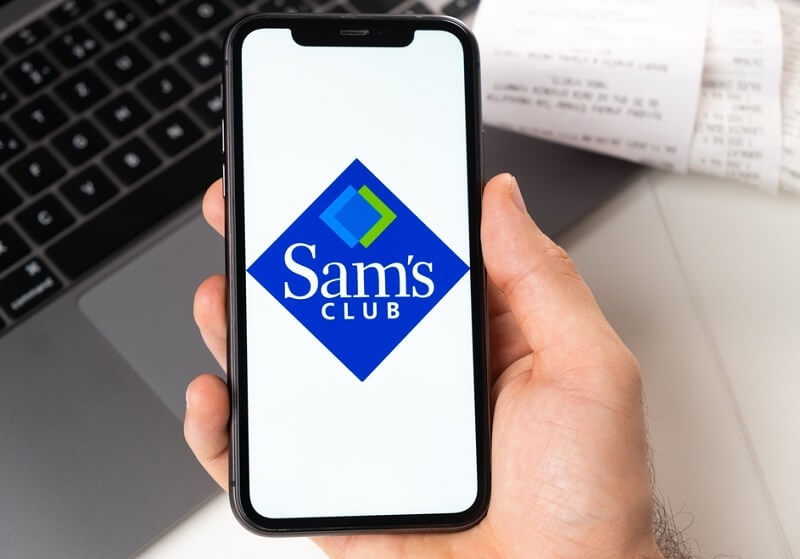 Man holding a smartphone Sam's Club application on the screen