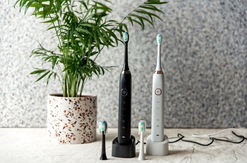 Modern rechargeable sonic or electric toothbrush set with charger in bathroom