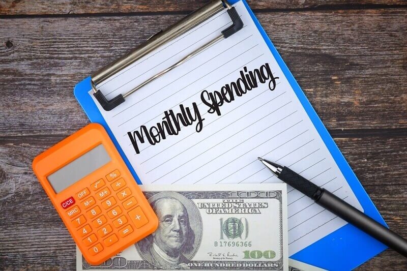 Monthly spending written on a clipboard with calculator