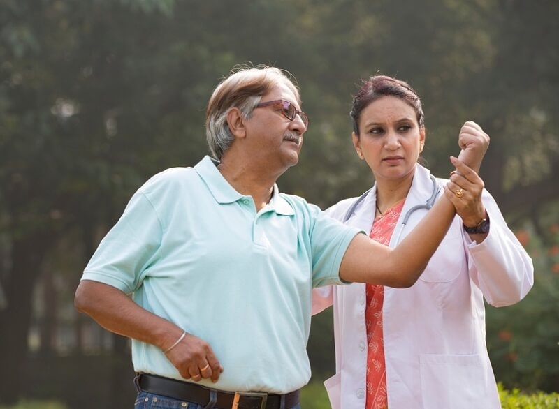 Senior patient making physiotherapy session with doctor