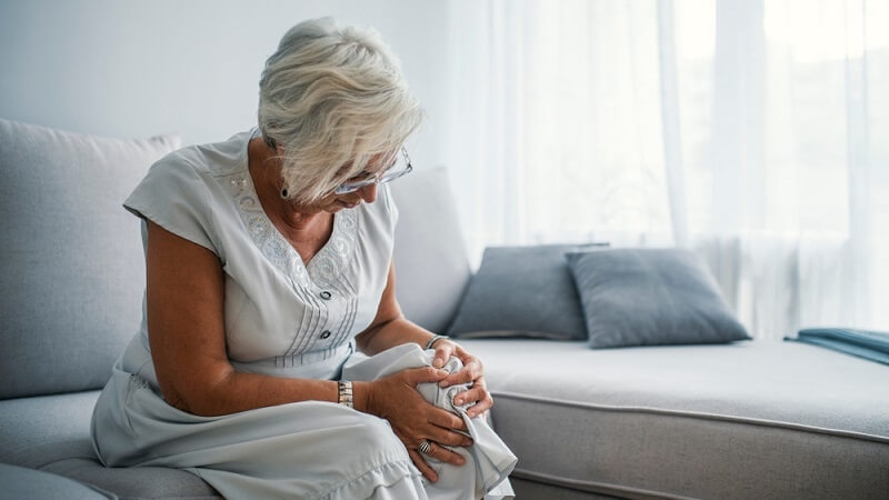 Senior woman holding the knee with pain