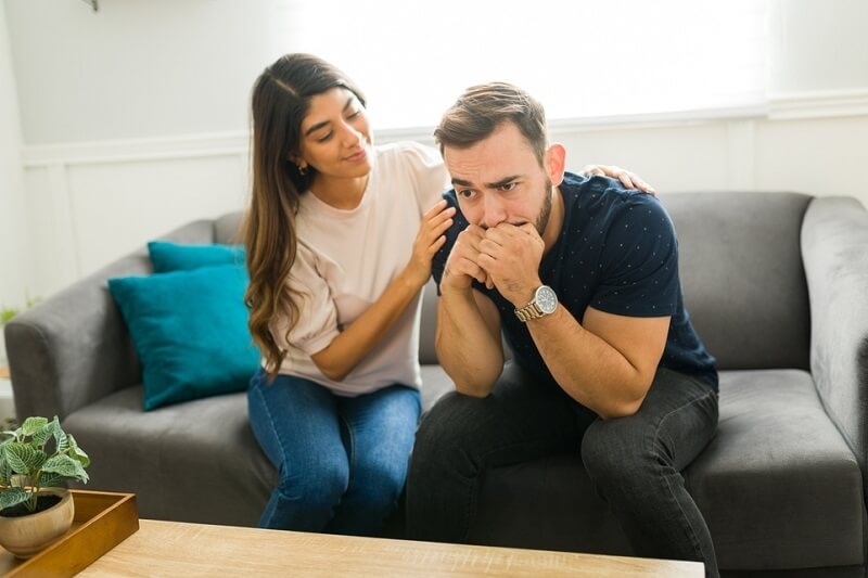 concerned woman comforting while talking with her sad depressed boyfriend crying about his problems