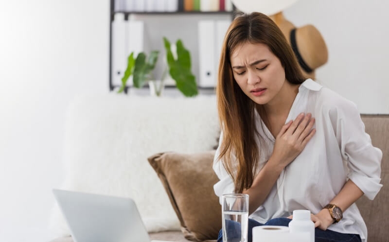 Young woman feeling pain in chest