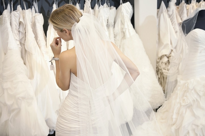  woman in wedding dress looking at bridal gowns