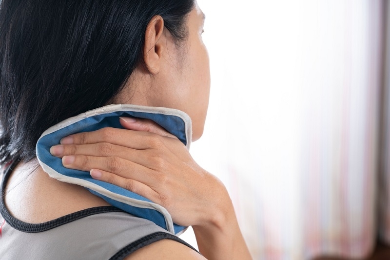 woman putting an ice pack on her neck pain