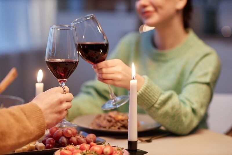 couple drinking wine enjoying romantic date night at home