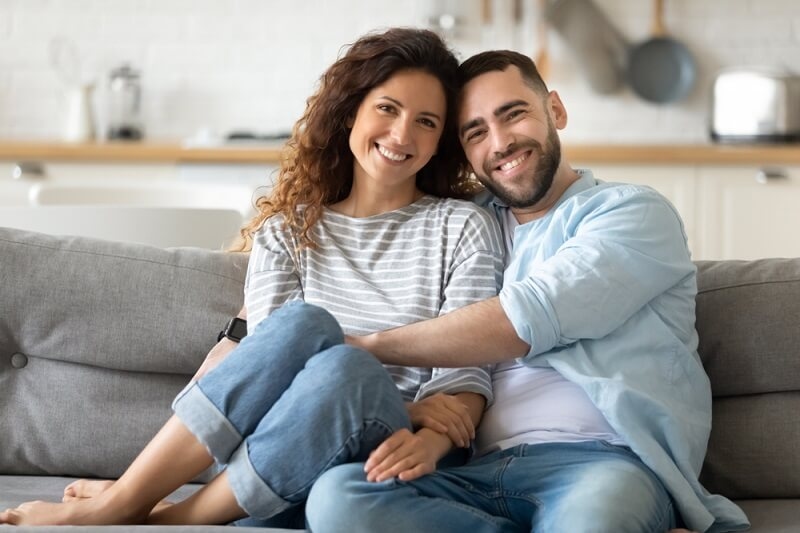 couple embracing sitting on sofa