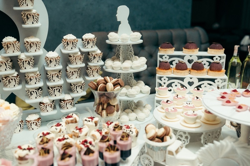 cupcakes, macarons and other candies on table