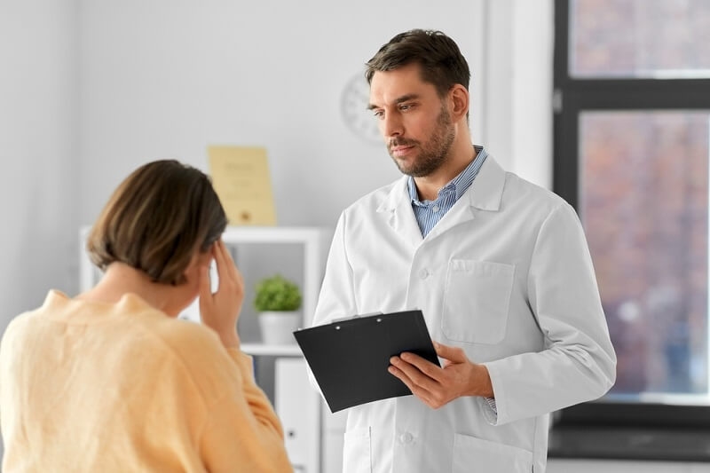 doctor checking female patient with Migraine or Headache