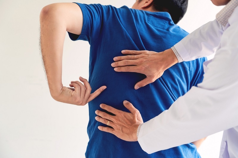 doctor is diagnosing the patient's back pain