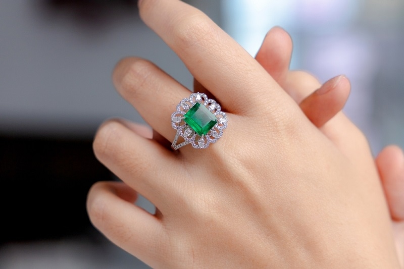 Emerald ring on the finger of a woman