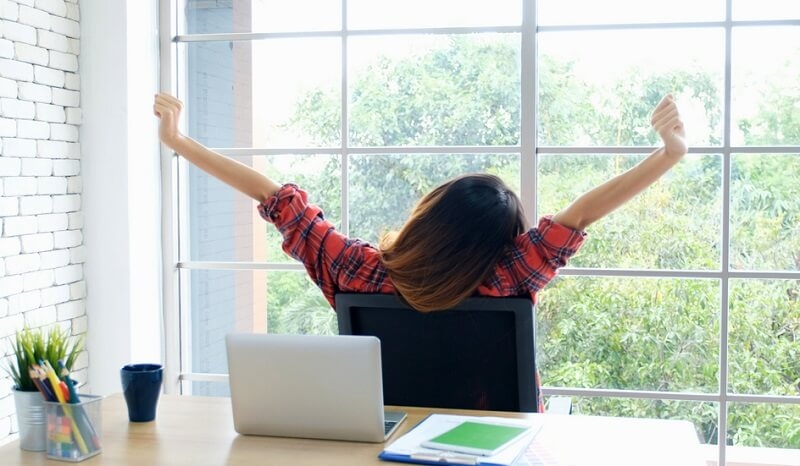 female student stretching body taking break from study. with laptop  at her desk
