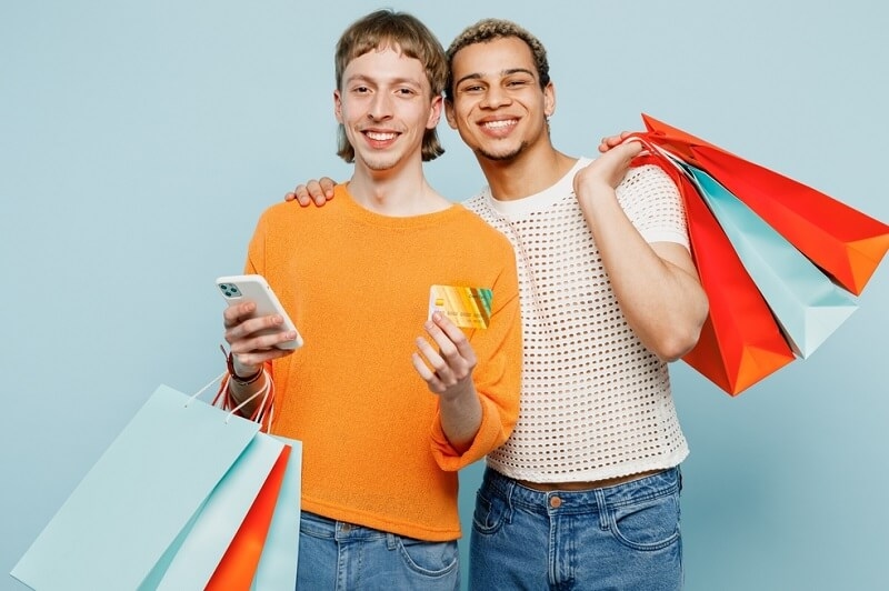 gay couple wearing casual clothes and holding shopping paper