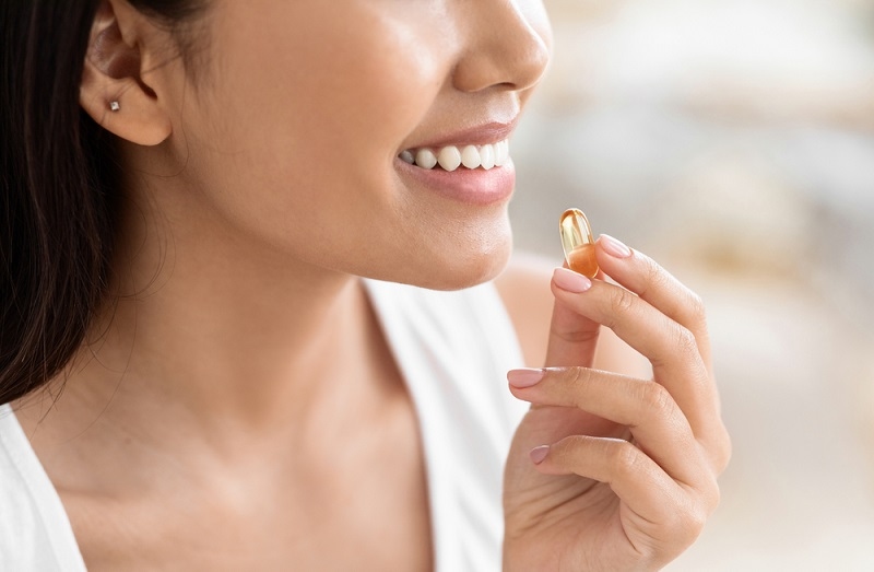 girl holding capsule of food supplement