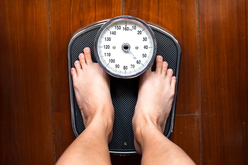 man standing on weighing apparatus