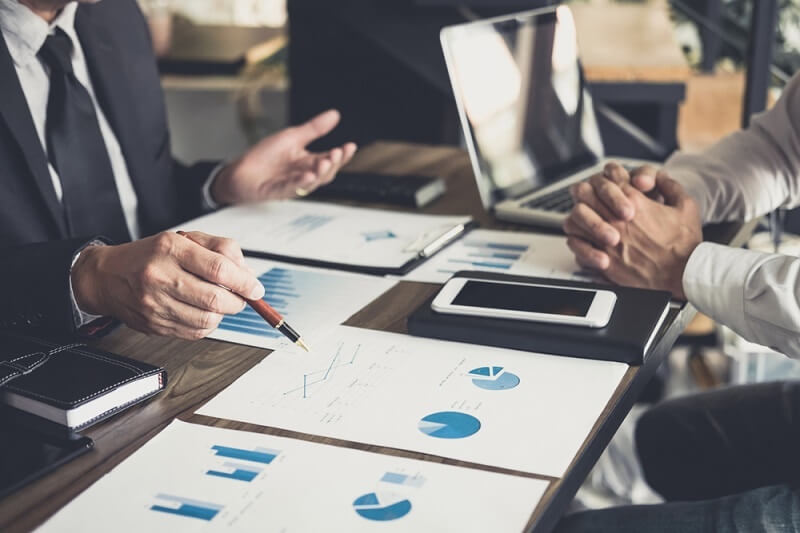 investor discussing plan financial graph data on office table