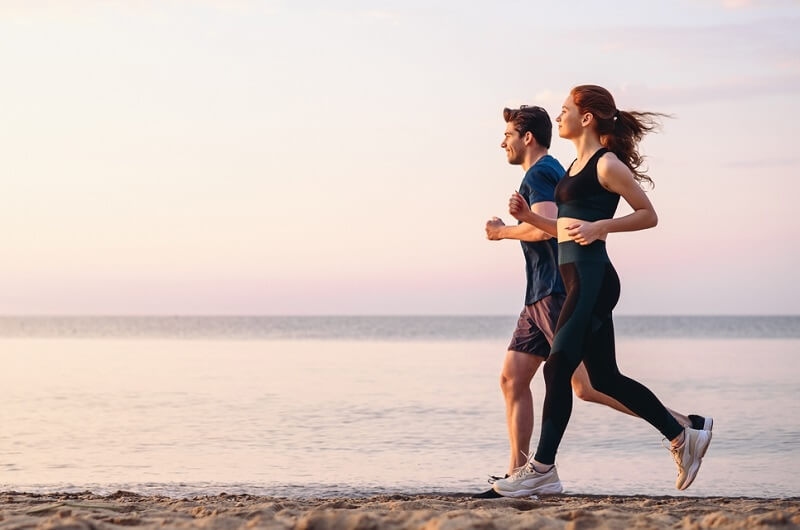 man and woman jogging outdoor on seaside