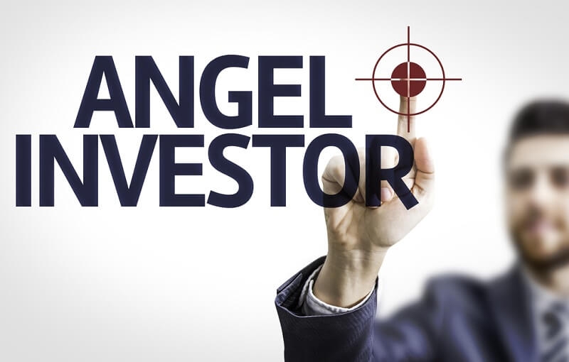 man pointing to transparent board with text Angel Investor