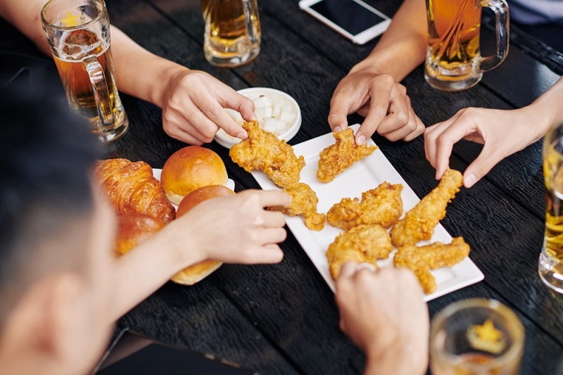 Friends are eating fried chicken together