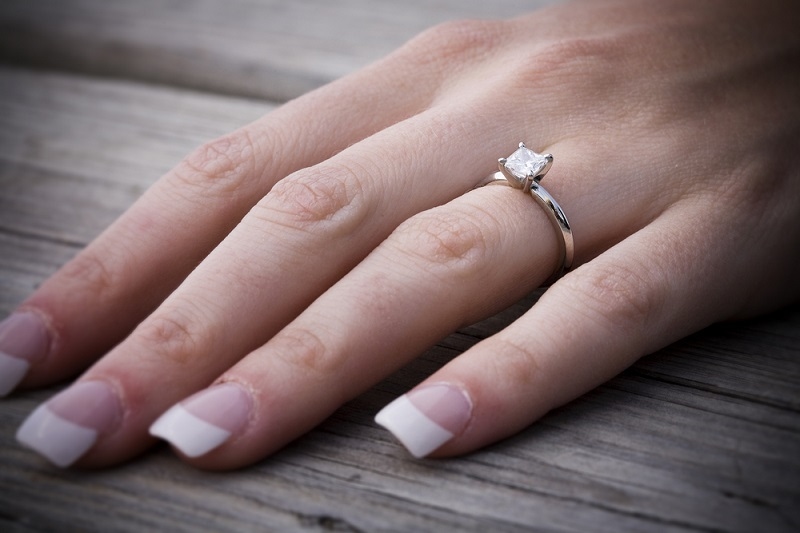 hand with Princess cut diamond engagement ring