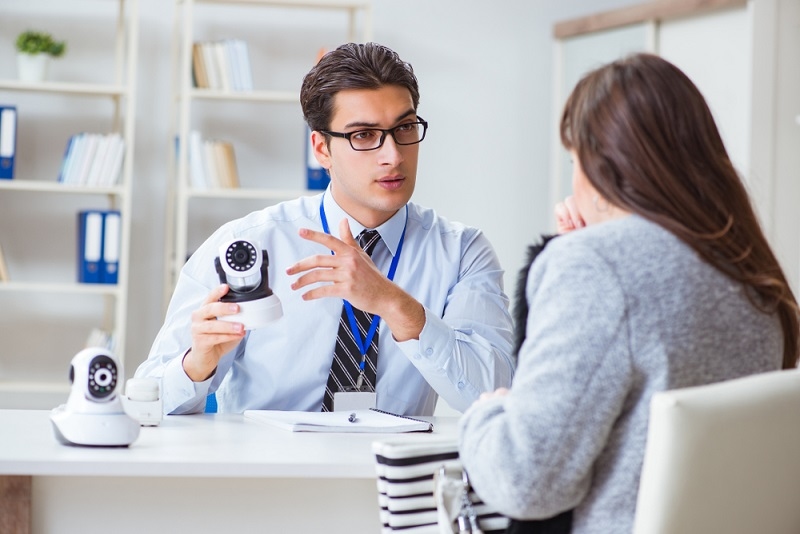 salesman helping woman to choose Home Security System