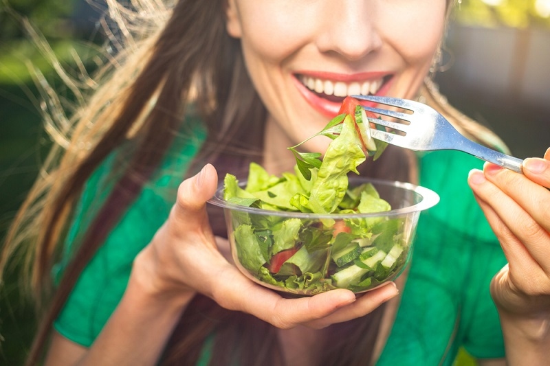 smiling woman eating salad