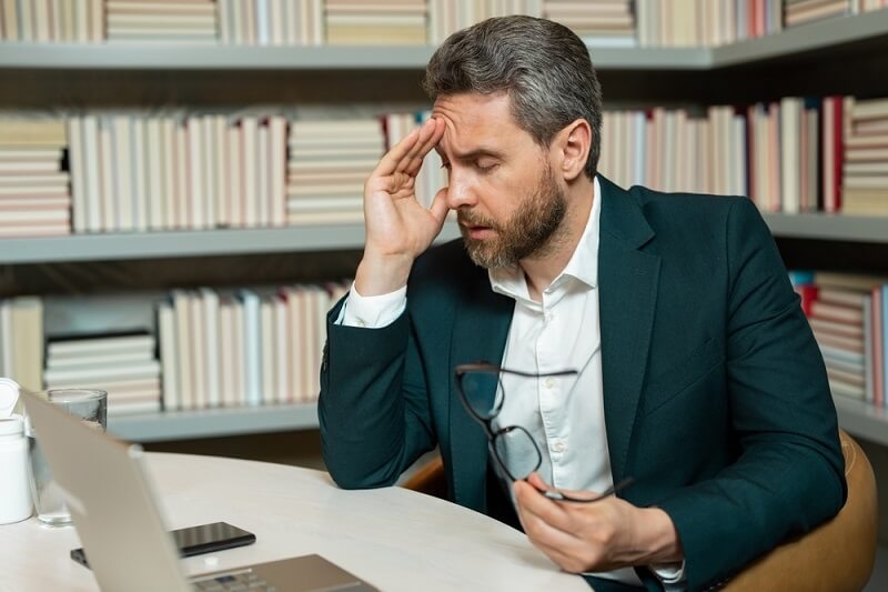 stressed man having head pain after working long time