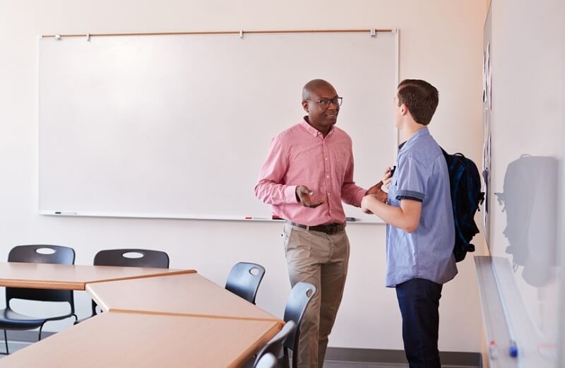 stuudent talking with teacher in class