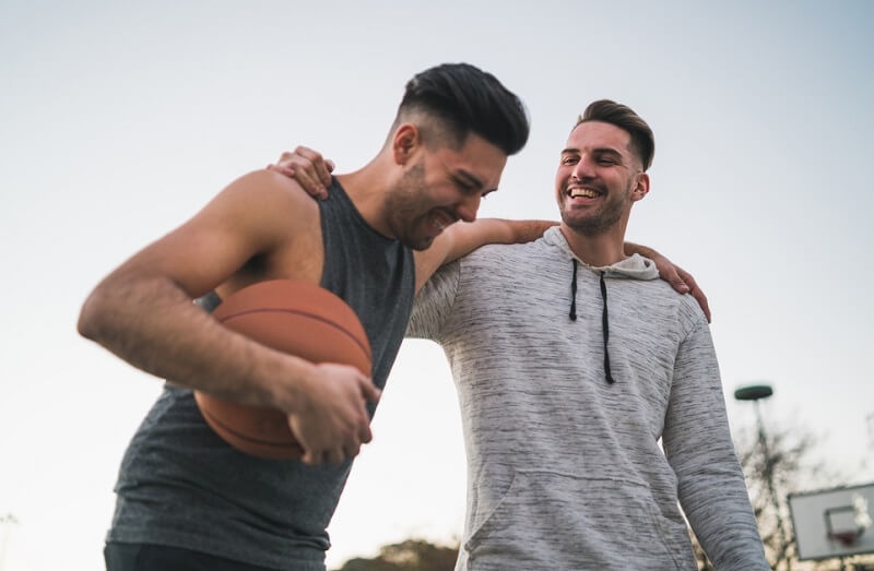 two friends having fun playing basketball