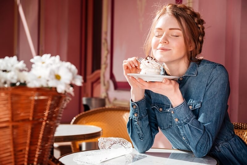 woman eating tasty cupcake