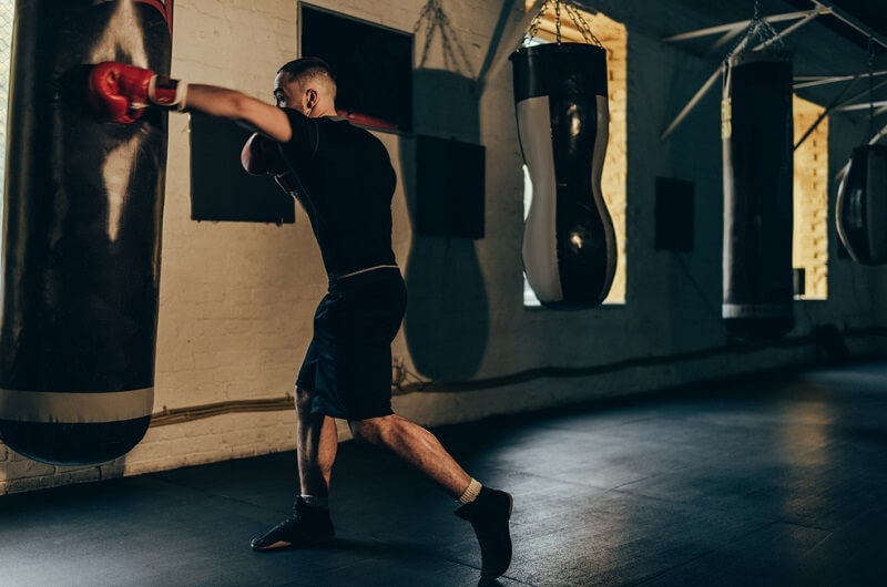 Young boxer training with punching bag