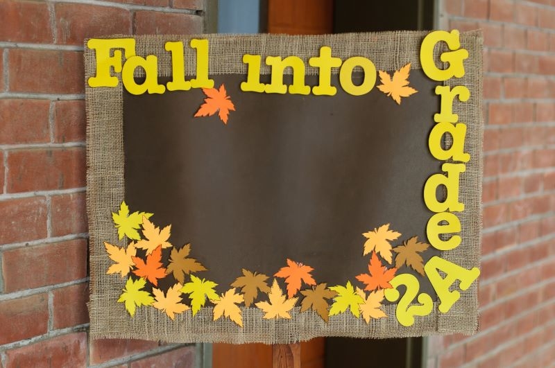 bulletin board with borders featuring autumn leaves, with phrase 'Fall Into Grade 2A,' providing classroom theme ideas