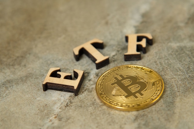Bitcoin coin with ETF text on stone background