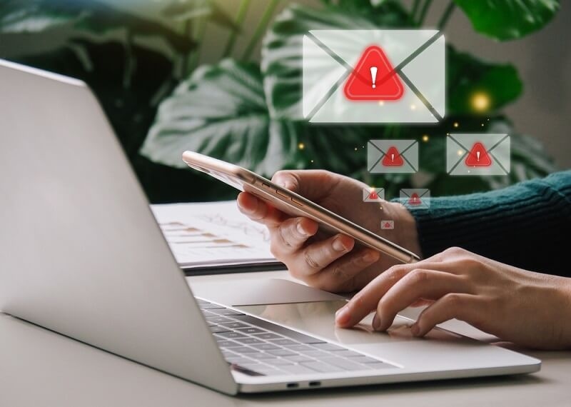 person checking emails on laptop and smartphone