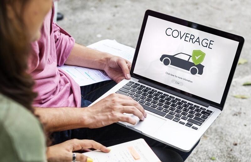 man checking auto insurance coverage on laptop