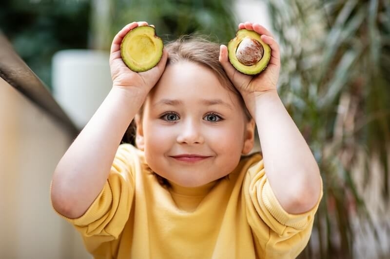 baby-girl-eating-avocado-to-boost-immune