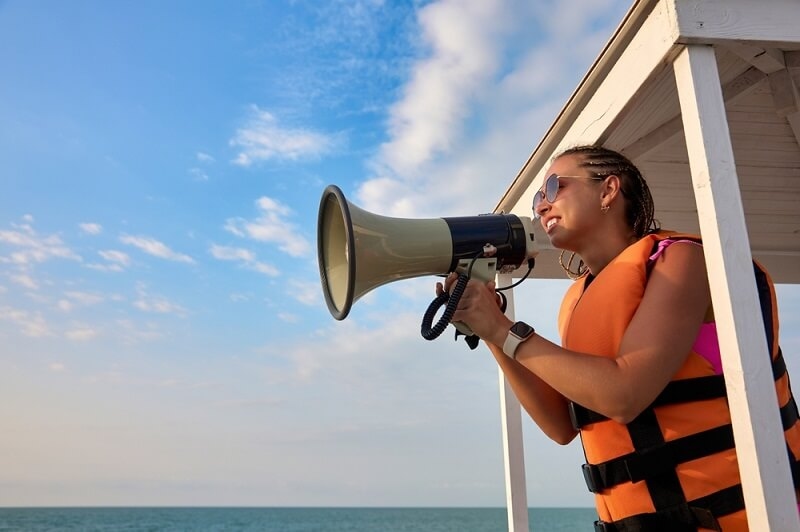 beach patroling woman officer alerting people