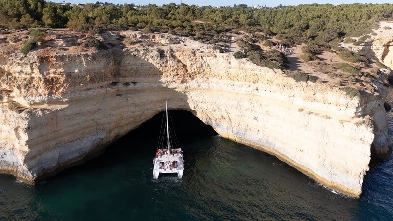 tourist on boat in portugal beach cave